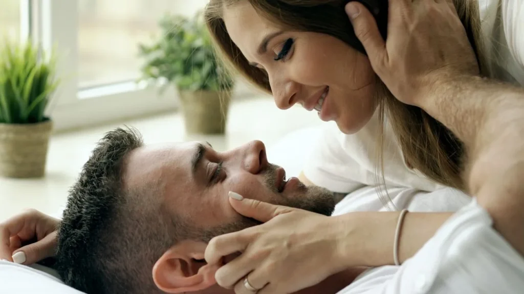 Two people laying in bed, embracing each other