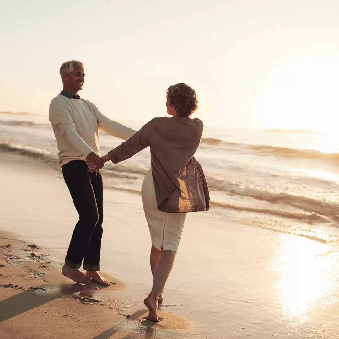 Happy Couple Holding Hands while Running on Beach - Men's Health Clinic